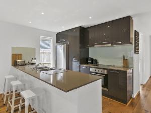 a kitchen with brown cabinets and a counter top at Paringa 15 Anglesea Beach House in Anglesea