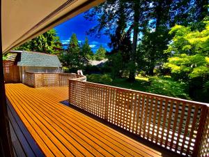 eine große Holzterrasse mit Blick auf einen Hof in der Unterkunft Lux White Rock Pool House Beachfront Resort like in Surrey