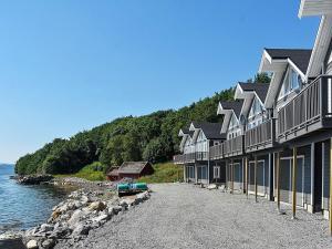 a row of houses next to a body of water at Holiday home VATNE in Vatne