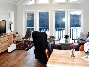 a living room with a couch and a tv at 6 person holiday home in VATNE in Vatne