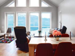 a living room with a table and chairs and windows at 6 person holiday home in VATNE in Vatne