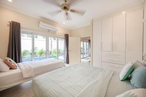 a bedroom with two beds and a large window at Majestic Residence Pool Villas 2 Bedrooms Private Beach in Pattaya South