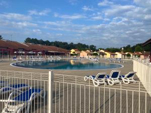 ein Pool mit Liegestühlen auf einem Parkplatz in der Unterkunft Soustons plage Maison terrasse 2 pers et 1 enfant Les villas du lac Tennis mini golf in Soustons
