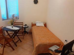 a small room with a bed and a table and a chair at Private Studio Intsaraki - Sveti Vlas in Sveti Vlas