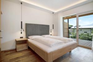 a bedroom with a large bed and a balcony at Sommersbergerhof 2017 in Bressanone +18 photos