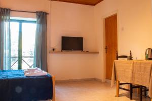 Il comprend un salon doté d'une télévision, d'une table et d'une fenêtre. dans l'établissement New Okella Hotel at Saittas, à Saittas