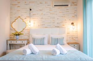 a bedroom with a large white bed with two pillows at Palm Studios in Limenas