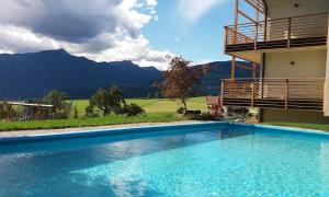 - une piscine en face d'un bâtiment avec des montagnes dans l'établissement Leierhof Brimella, à Rodengo
