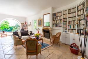 uma sala de estar com um sofá e uma lareira em Le Domaine des Mûriers - charme, chic, calme en Provence Côte d'Azur em Plascassier