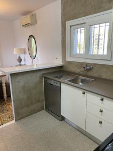 cocina con fregadero y encimera con espejo en VILLA CATALUNYA, en Cambrils