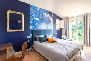 a blue bedroom with a bed and a mirror at Le Domaine des Mûriers - charme, chic, calme en Provence Côte d'Azur in Plascassier +34 photos