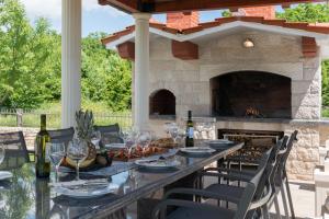 patio con tavolo e camino di Villa Miam a Velika Cista