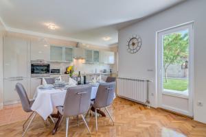 una cucina e una sala da pranzo con tavolo e sedie di Villa Miam a Velika Cista Altre 37 foto