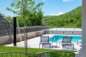 un patio con sedie e una piscina di Villa Miam a Velika Cista