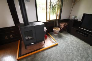 a living room with a fireplace and a plant at 貸切宿にんじん in Hara