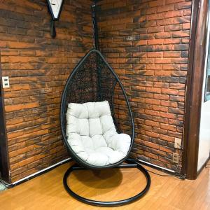 a white chair in a room with a brick wall at 貸切宿にんじん in Hara