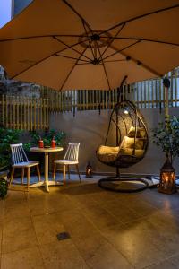 eine Terrasse mit einem Sonnenschirm, Stühlen und einem Tisch in der Unterkunft BLACKHAUS Apartments in Thessaloniki