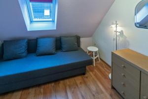ドルヌムにあるFerienwohnung Reginaの窓付きの客室で、青いソファが備わります。