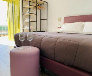 um quarto com uma cama e dois copos de vinho em Vesuvio Inn Bed & Wine Experience em Boscotrecase