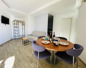 Boscotrecase的住宿－Vesuvio Inn Bed & Wine Experience，一间带木桌和紫色椅子的用餐室