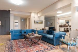 una sala de estar con sofás azules y una mesa. en Regina Mare Hotel, en Paralia Katerinis