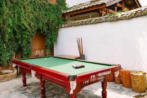 a pool table sitting next to a white wall with afits at Chunjian Guesthouse in Kunming