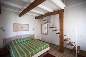 a bedroom with a bed and a spiral staircase at Locanda degli Artisti in Tortolì