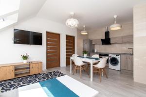 a kitchen and dining room with a table and chairs at Apartament Perła in Ustka