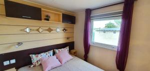 - une chambre avec un lit et une fenêtre avec des rideaux violets dans l'établissement Cabañas las Rosas, à Pollos