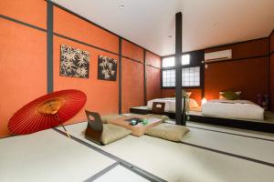 een kamer met een bed en een rode paraplu bij NAKAZ Machiya , Osaka Umeda in Osaka