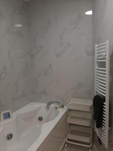 La salle de bains blanche est pourvue d'une baignoire et d'un lavabo. dans l'établissement My holiday home, à Rhodes