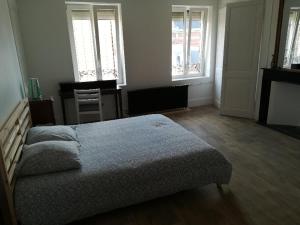 a bedroom with a bed and two windows at Bruneval lodge in Dunkerque