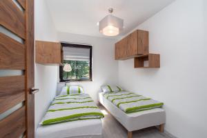 Cette chambre comprend 2 lits et une fenêtre. dans l'établissement Apartament Kapitański, à Ustka