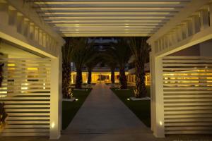 un couloir avec des palmiers et des lumières dans un bâtiment dans l'établissement Villa Del Mare Spa Resort, à Cervia