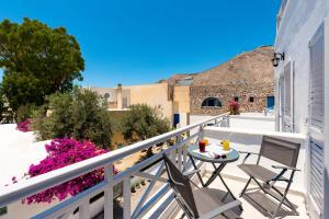 a balcony with two chairs and a table on it at Kasteli Luxury Rooms in Perissa