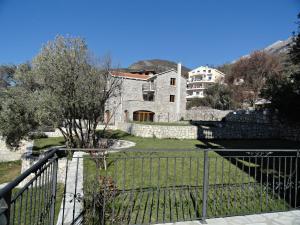 a large stone house with a fence in front of it at Apartments Oasis in Budva