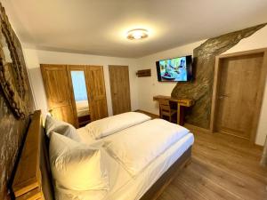 a bedroom with a bed with a television on the wall at Hotel Restaurant Unikat in Zeltingen-Rachtig