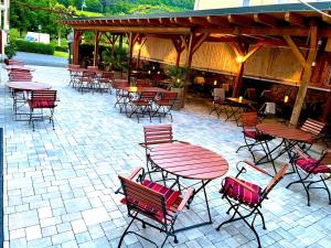 a patio with tables and chairs and a pavilion at Hotel Restaurant Unikat in Zeltingen-Rachtig