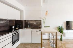 a kitchen with white cabinets and a white table at Apartamento Piccadilly Suite in Torremolinos