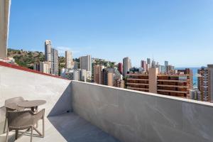 a balcony with a table and chairs and a city at Halley Hotel & Apartments Affiliated by Meliá in Benidorm