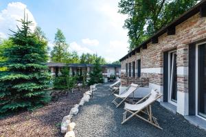 patio z krzesłami i drzewem obok budynku w obiekcie Noble Apartment & Sauna ZONE w Zabierzowie