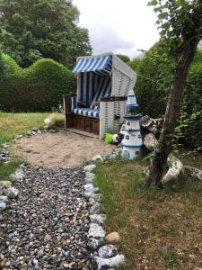 a chair and a lighthouse sitting in a garden at Pension zum Brauhaus in Stralsund