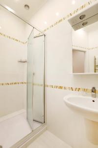 La salle de bains est pourvue d'une douche et d'un lavabo. dans l'établissement Universal, à Svetlogorsk