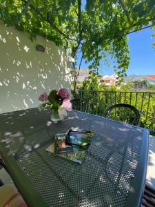 a green table with a vase of flowers on it at Apartments Mare in Mlini