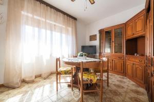 cocina con mesa, sillas y ventana en House Antonella - Wonderful Holidays on a Budget en Gonnesa