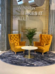 two chairs and a table in front of a store at IBIS Styles Kaunas Centre in Kaunas