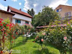 a garden in front of a house with flowers at Modern&Cozy Bosnian house with GARDEN+FREE parking in Sarajevo