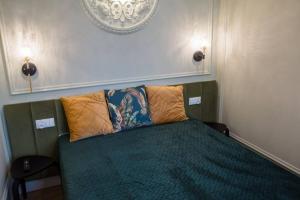 托倫的住宿－Domek z Piernika，一间卧室配有带两个枕头的绿色床