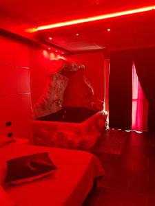 a red room with two beds and a tub at Hotel La Fayette in Licola