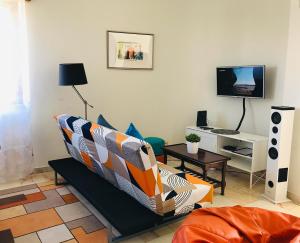 uma sala de estar com um sofá e uma televisão em Casa do Mar em Costa da Caparica